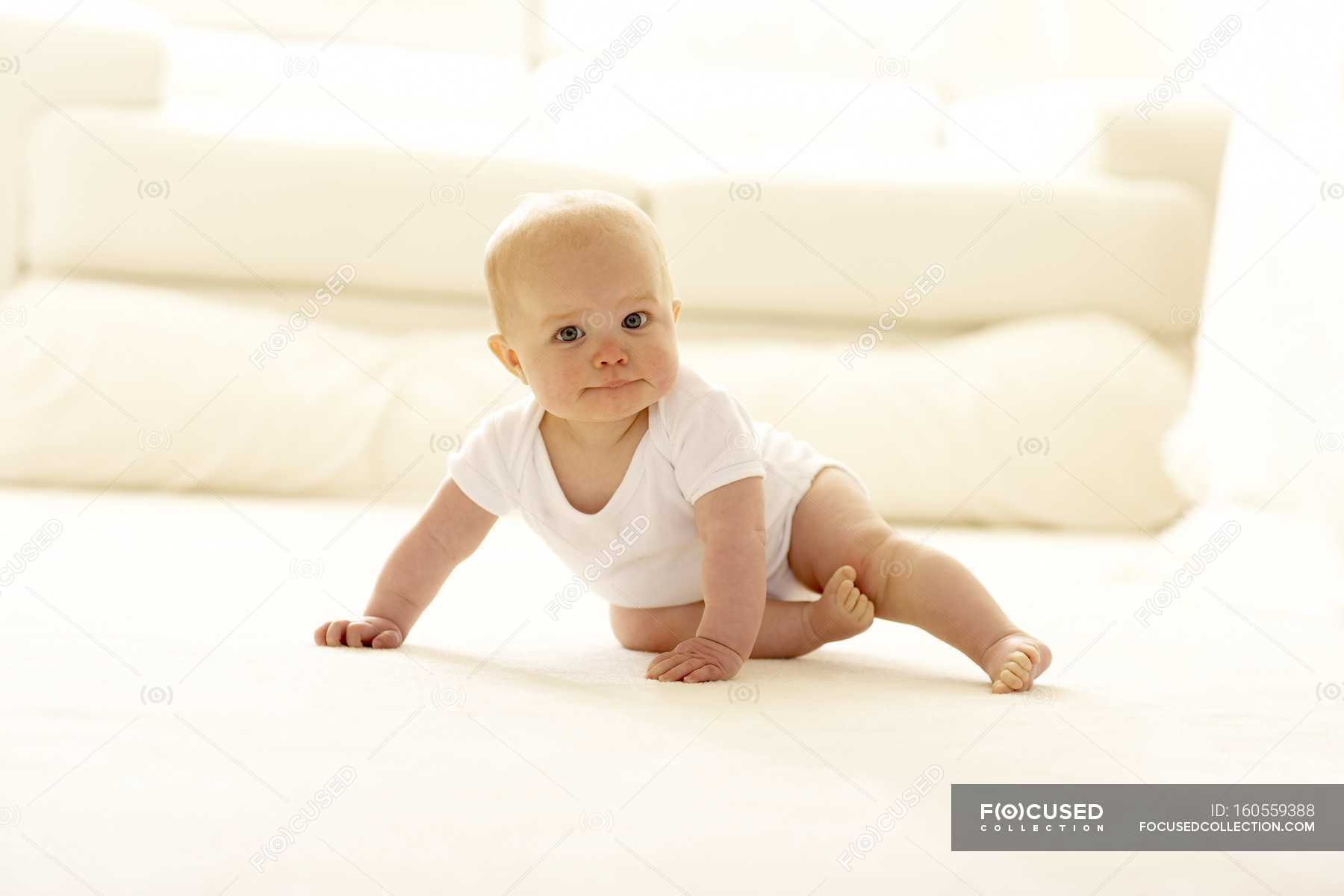 Baby girl crawling across the floor. — adorable, selective focus ...