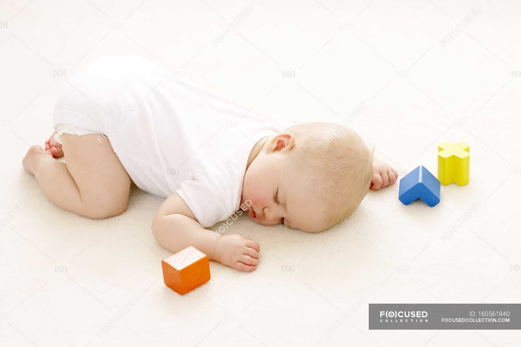 Baby Girl Sleeping On Floor Surrounded By Toy Blocks Childhood