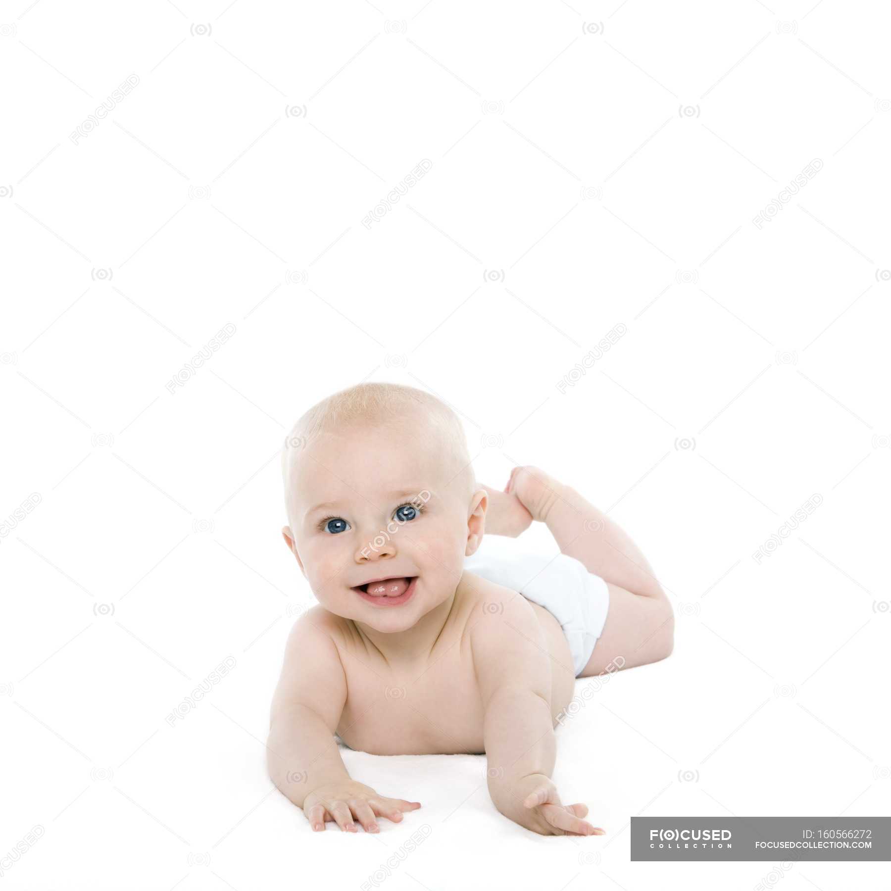 Baby boy lying on front on white 