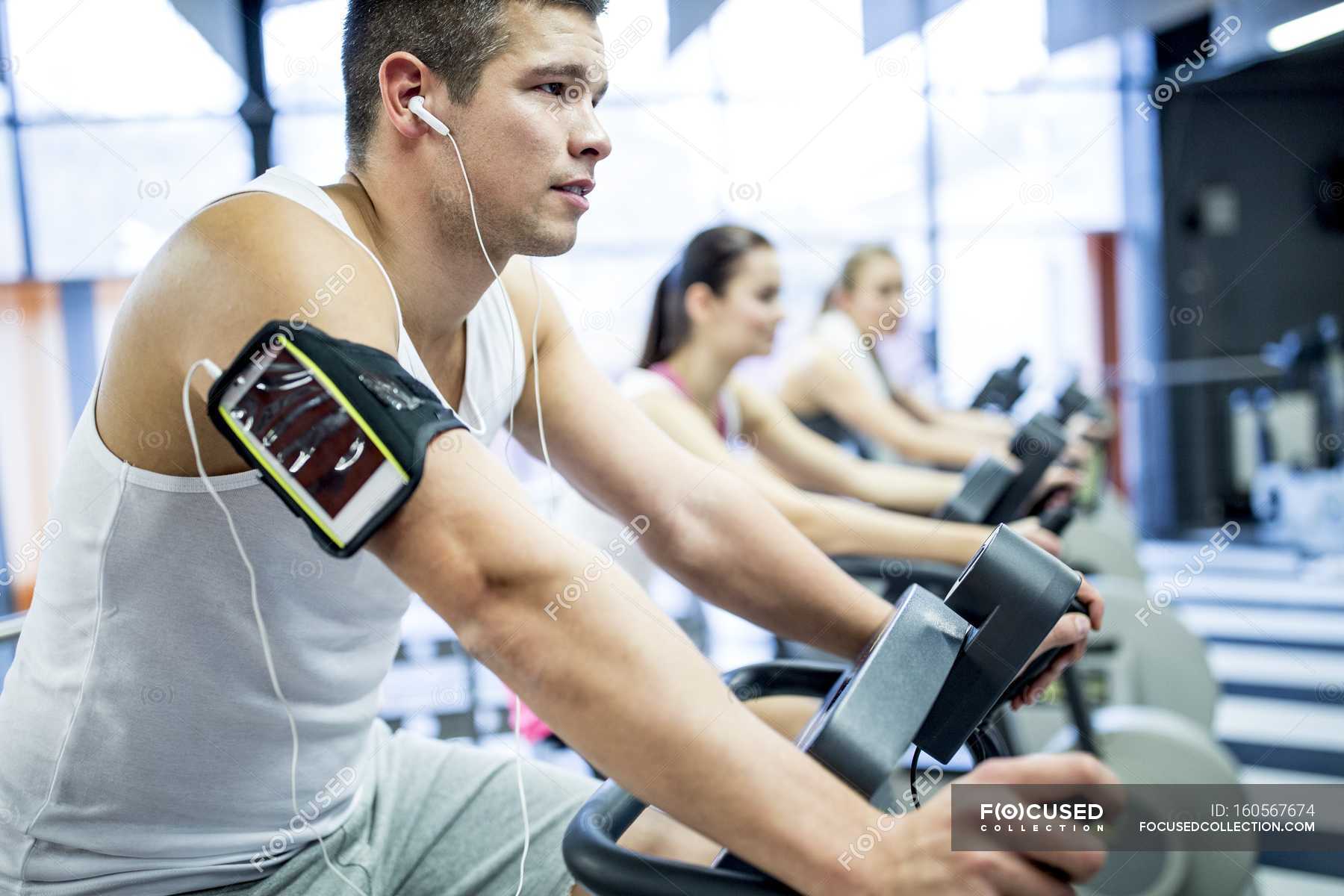 young-man-listening-to-music-while-working-out-in-gym-smartphone