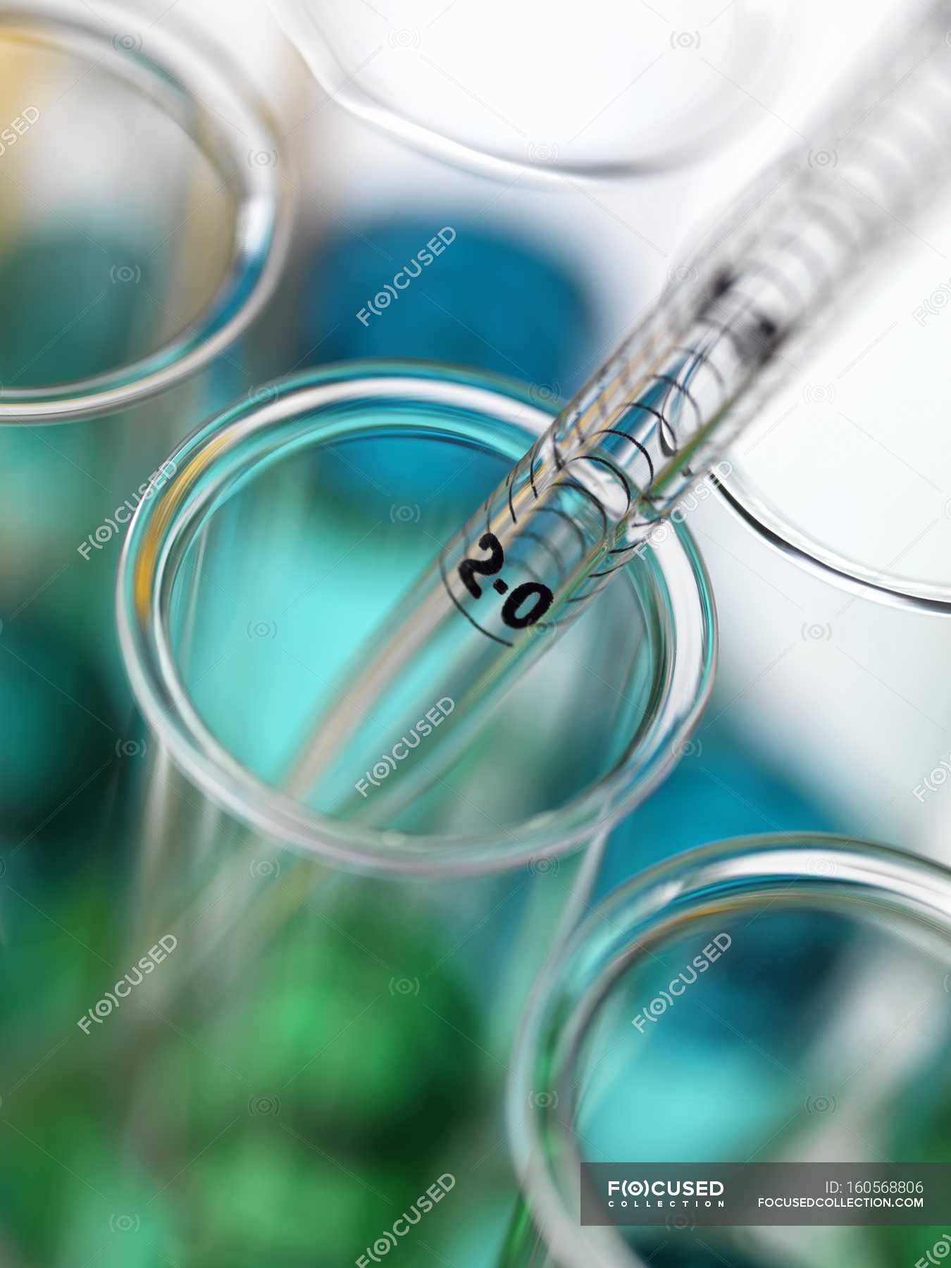 Close-up of pipetting colorful liquids into test tubes. — lab, units ...