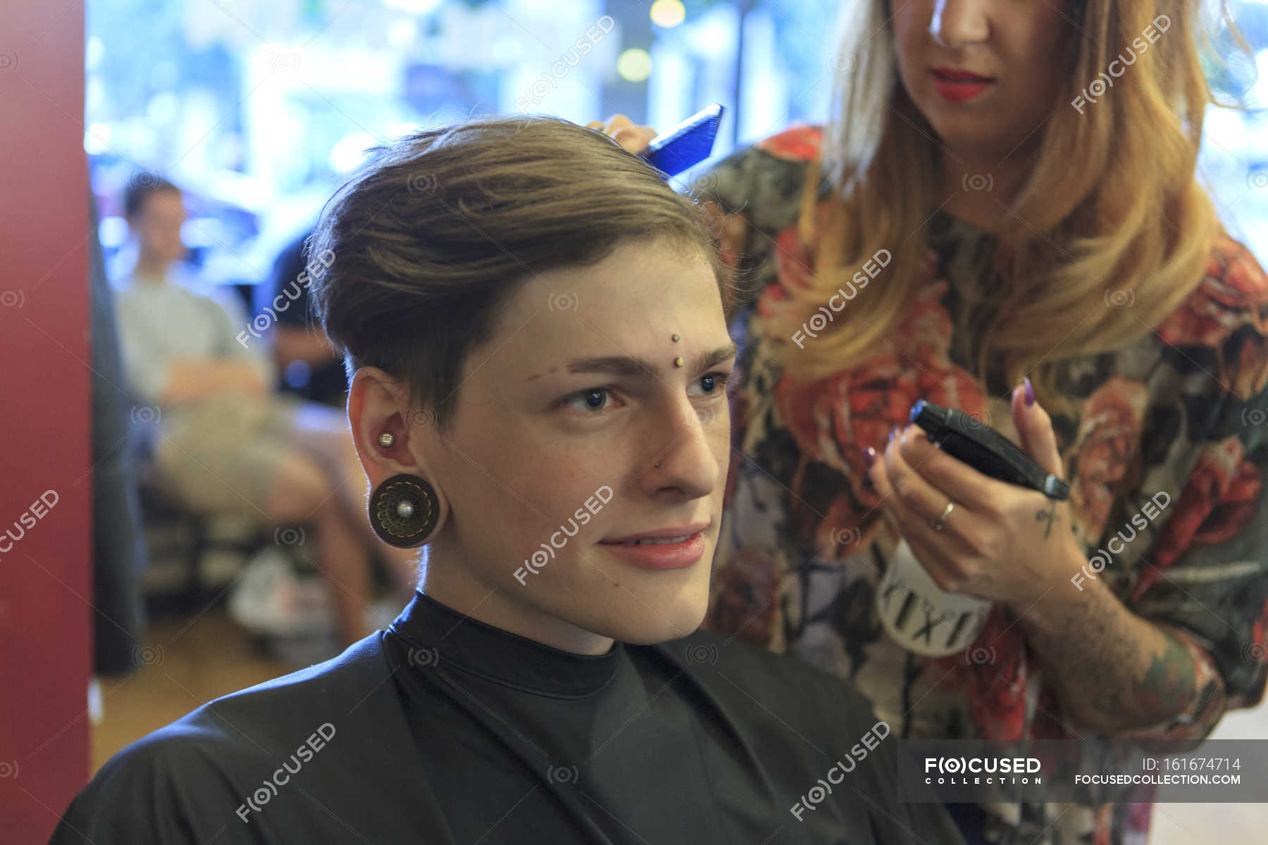 Trendy Young Man With Piercing Having Haircut In Hair Salon Two