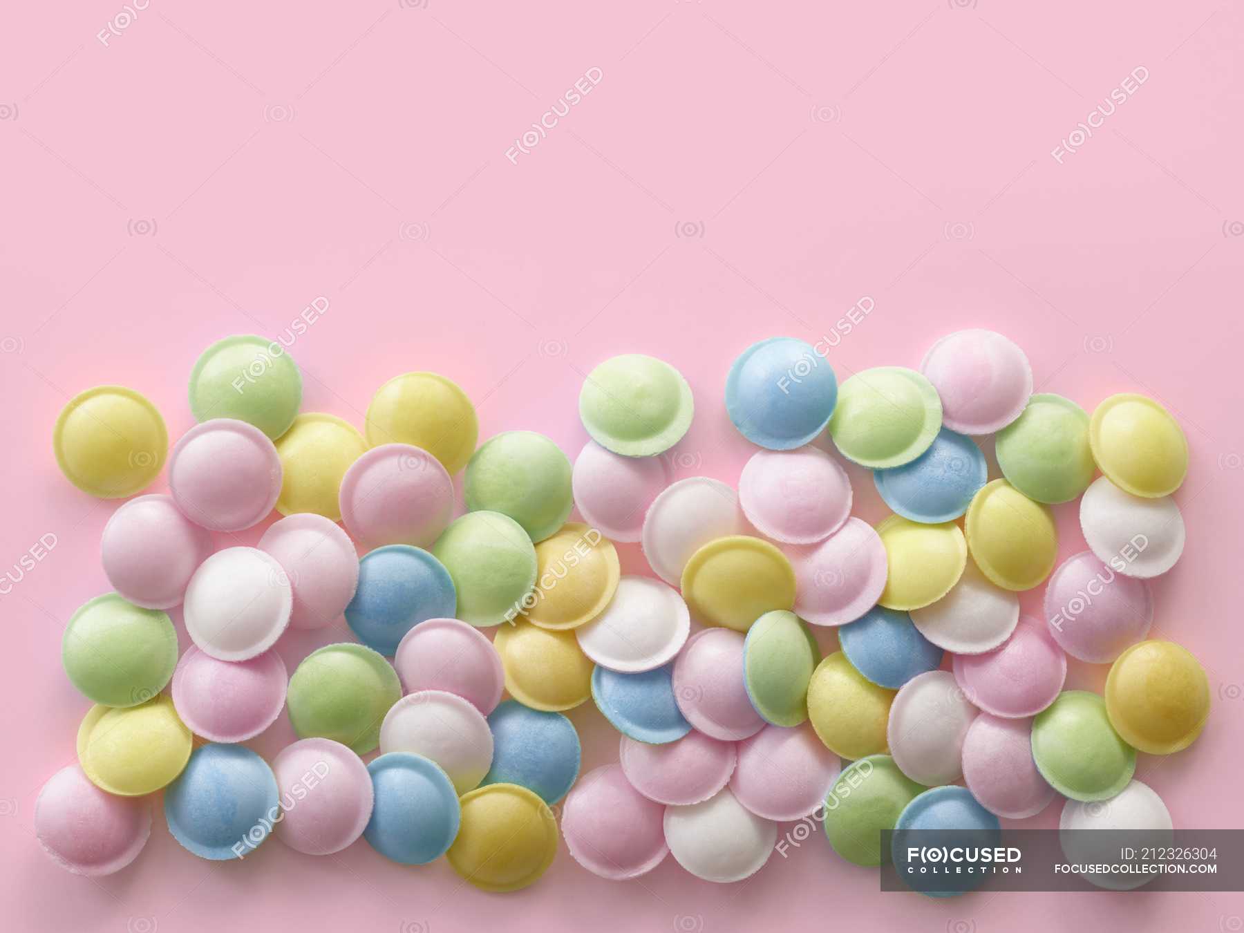 Pastel Colored Sweets Against Pink Background Copy Space