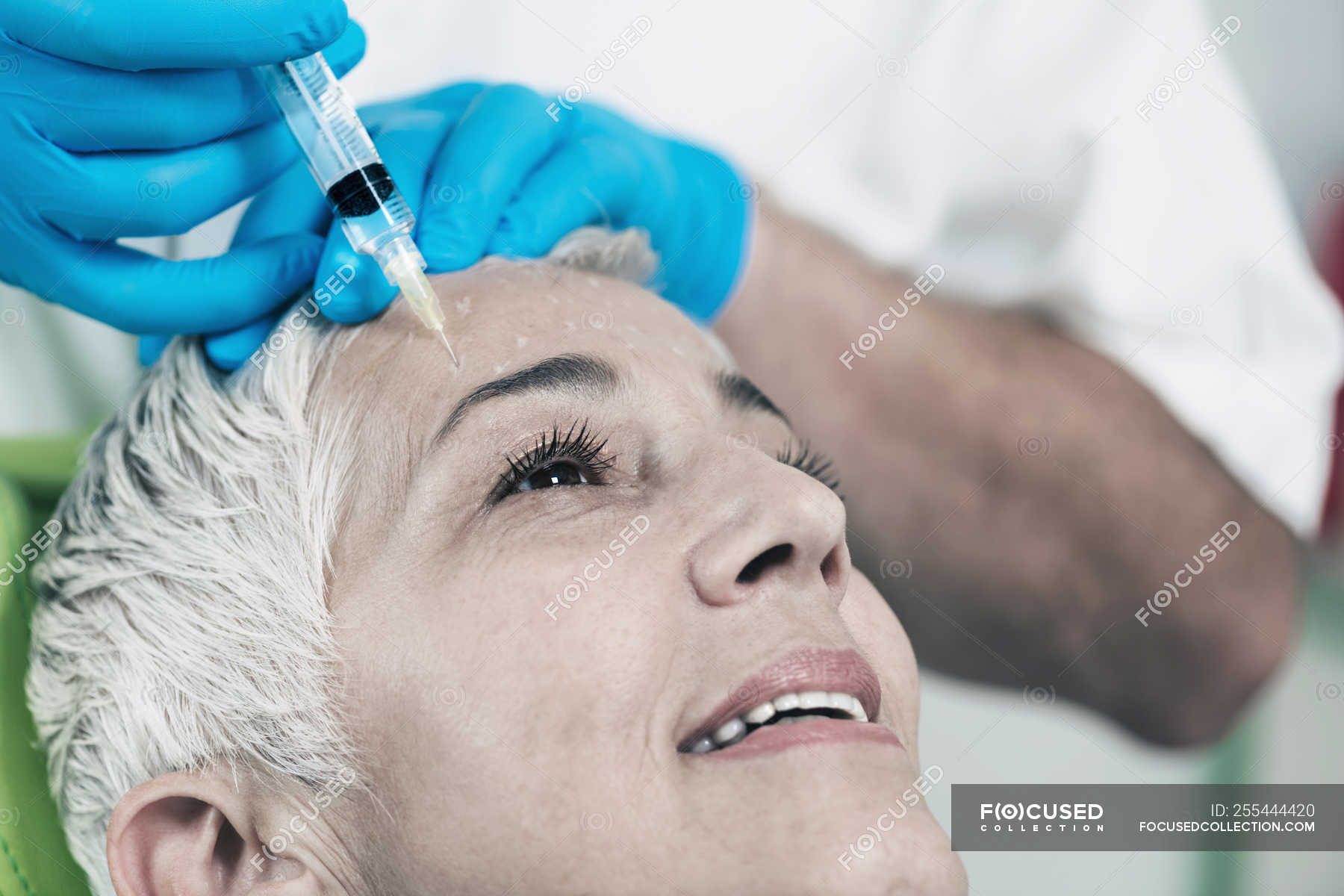 Mature Woman Receiving Botox Injection In Forehead In Cosmetology Clinic — Scincare People 