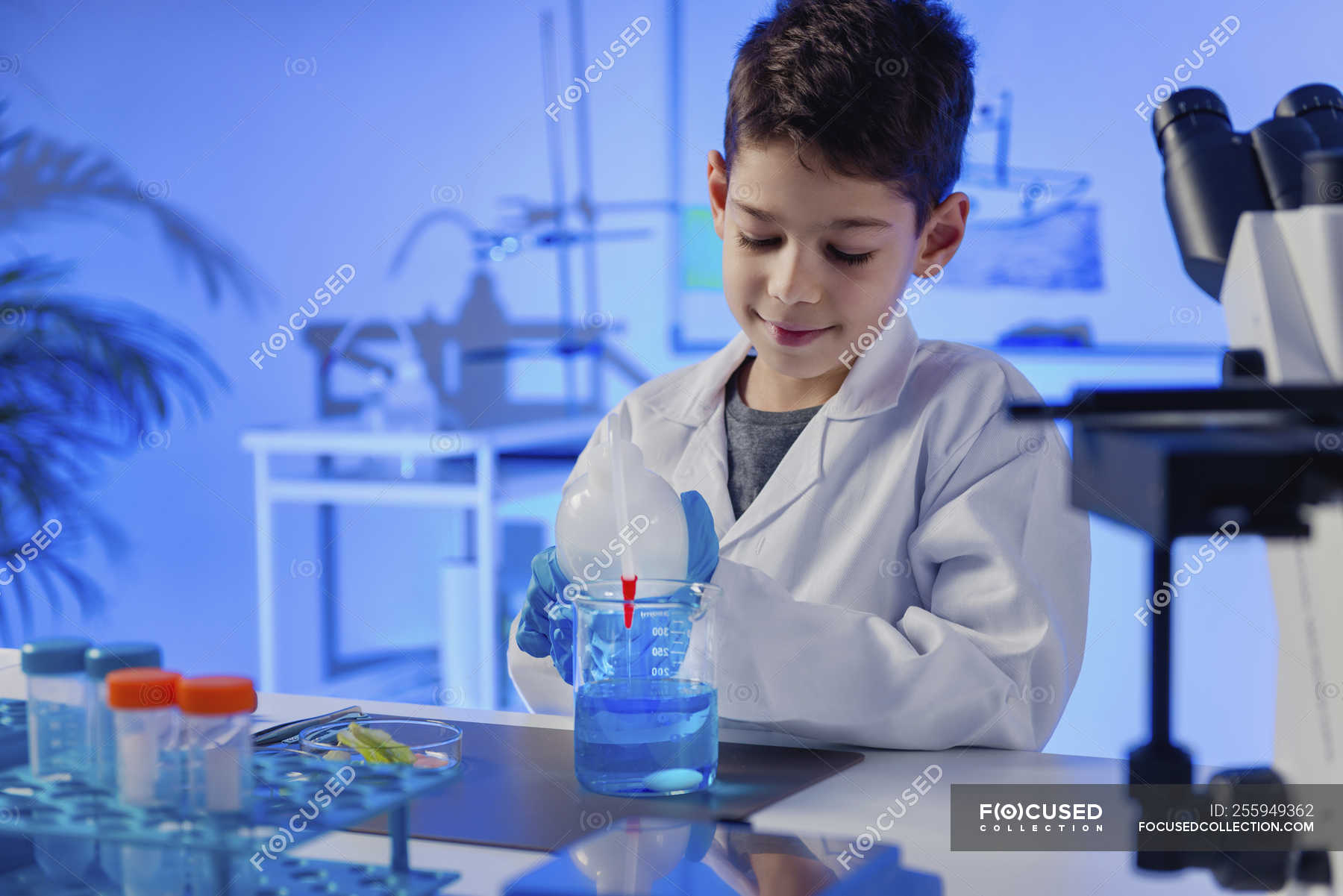 Schoolboy doing science experiment in school chemistry laboratory ...