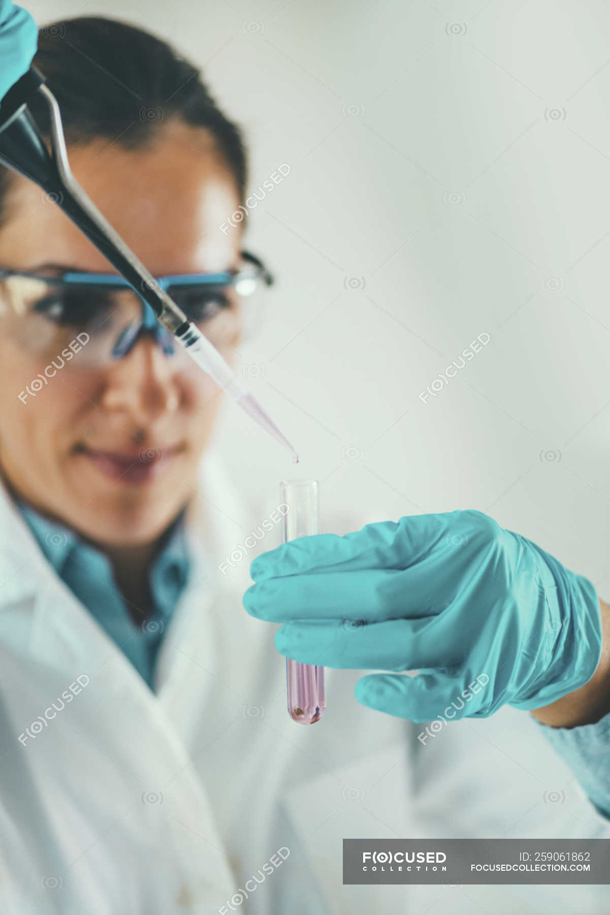 Laboratory technician using micro pipette while sampling into test tube