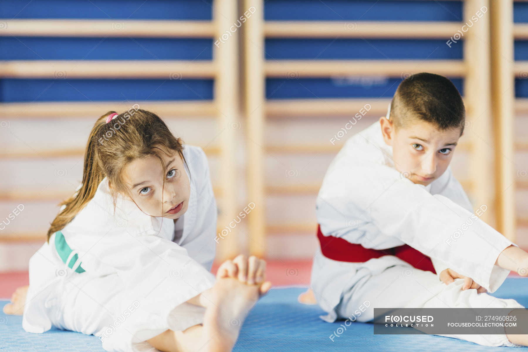 Boy and girl stretching in taekwondo class. — taekwondo training
