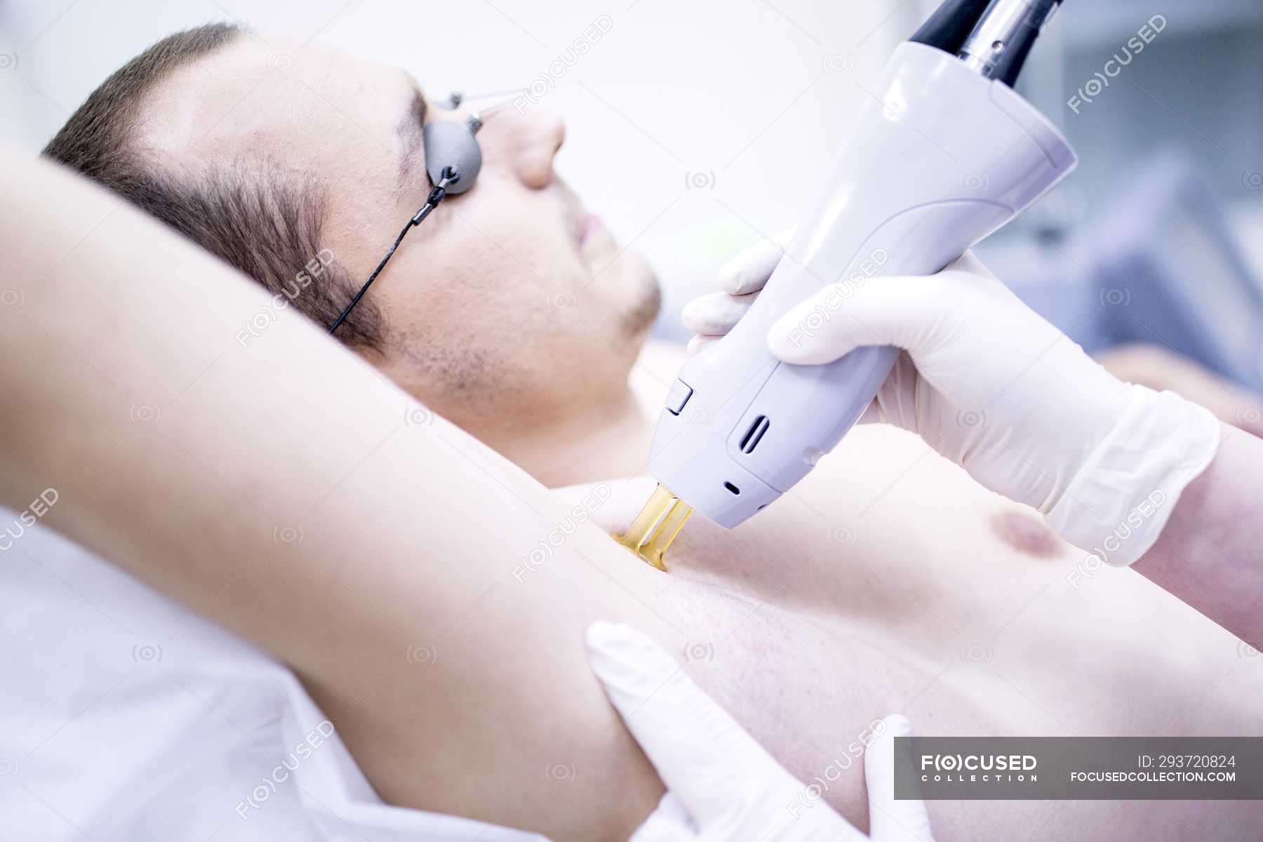 Man Getting Laser Hair Removal Treatment For Armpit Two People