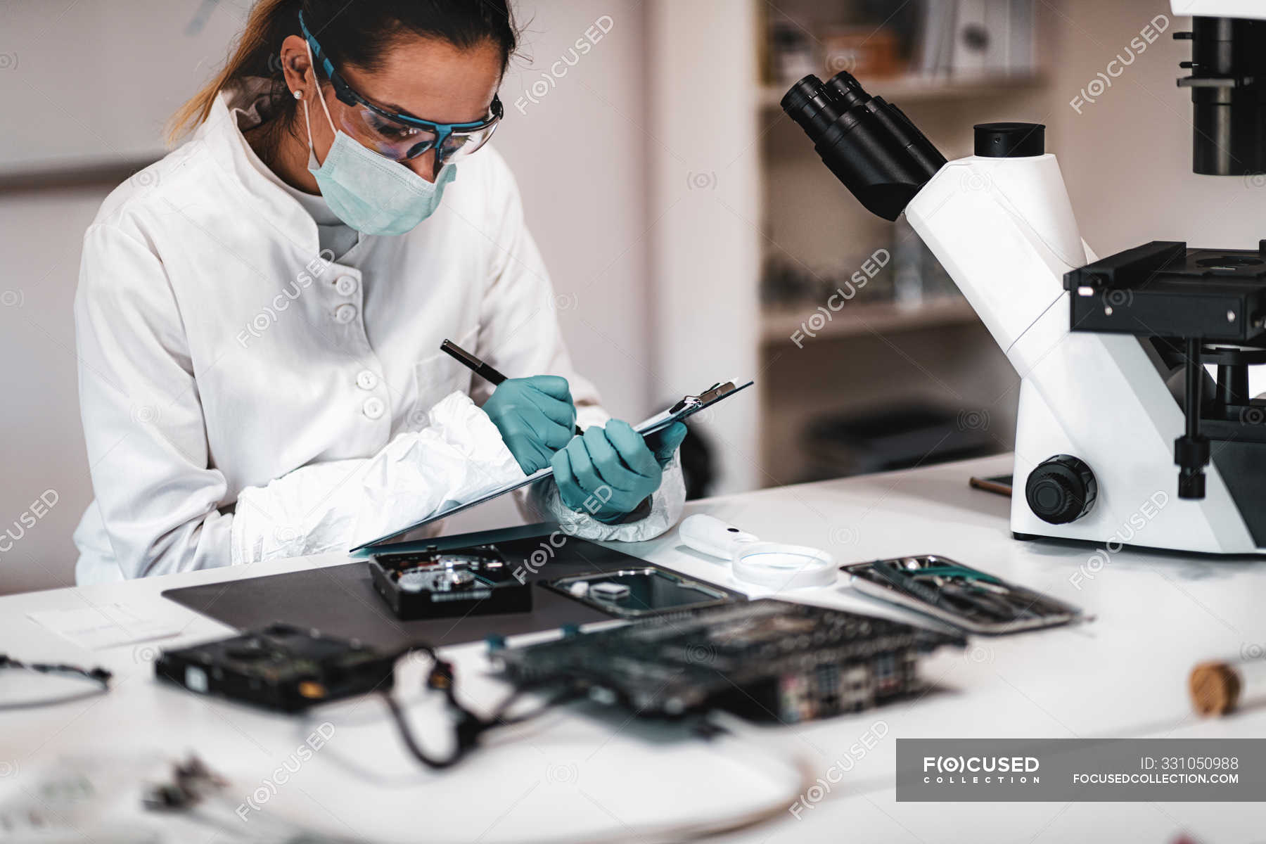 Digital forensic science technician taking notes while examining