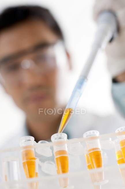 Close-up de cientistas do sexo masculino pipetando em tubos de ensaio
. — Fotografia de Stock