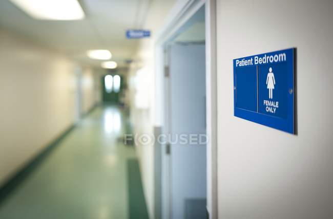 Señal azul de la sala de sexo único femenino en la puerta del hospital . - foto de stock