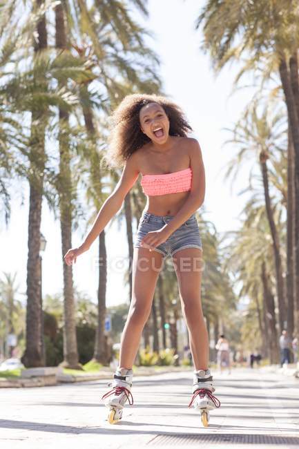 Mixed Race Teenager Mädchen Inlineskaten auf der Straße. — Stockfoto