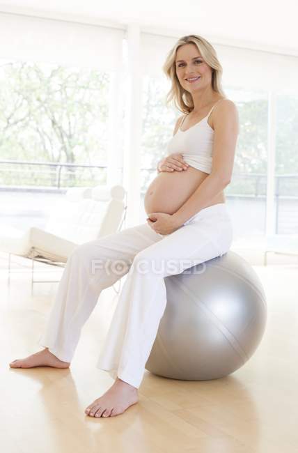 Pregnant woman sitting on an exercise ball — Stock Photo