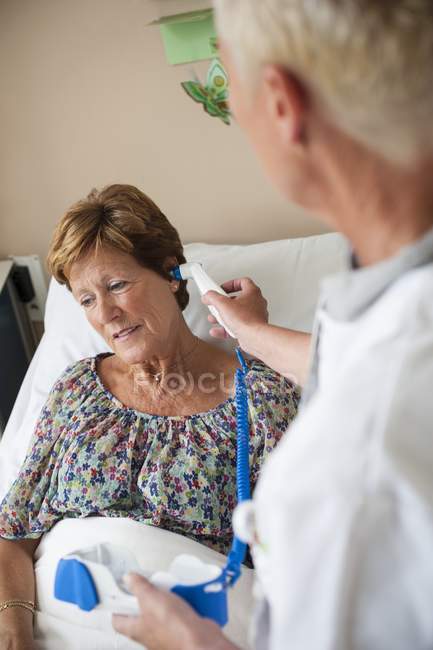 Nurse taking patient temperature with digital thermometer. — Stock Photo