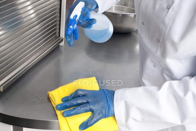 Close-up of kitchen worker cleaning work surface. — Stock Photo