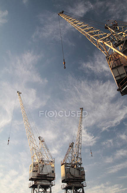 Gru industriali su sfondo cielo nuvoloso . — Foto stock