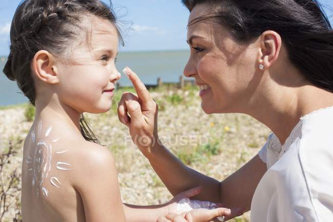 Mother applying sun cream to daughter. — Stock Photo