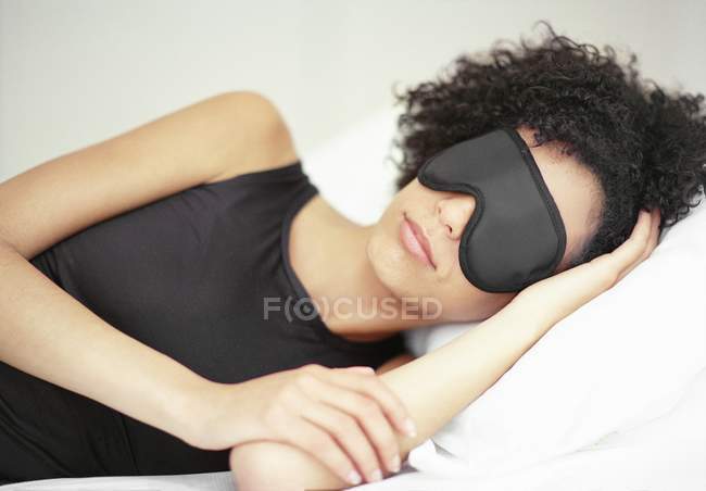 African american woman sleeping in black sleep mask. — Stock Photo