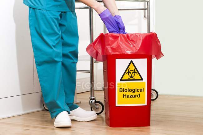 Cropped view of doctor throwing away used gloves. — Stock Photo