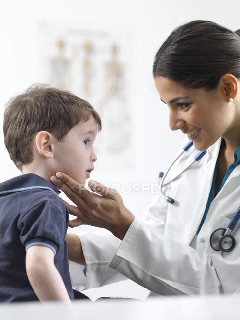 Pediatra do sexo feminino verificando glândulas menino pré-escolar . — Fotografia de Stock