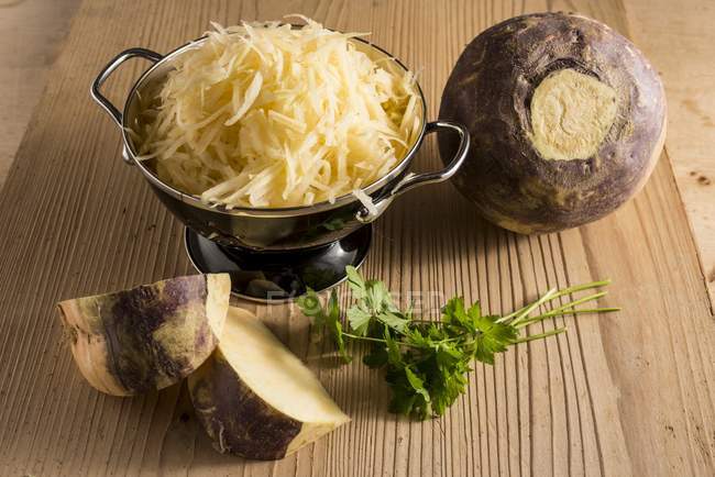 Grated swede in bowl on table. — Stock Photo