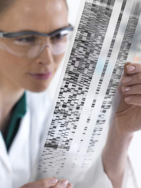 Femme scientifique regardant l'autoradiogramme ADN . — Photo de stock
