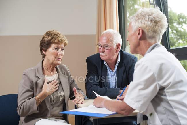 Reunión de enfermeras en consulta hospitalaria con pacientes de edad avanzada . - foto de stock