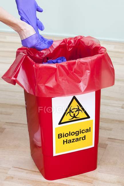 Close-up view of doctor throwing away used gloves. — Stock Photo