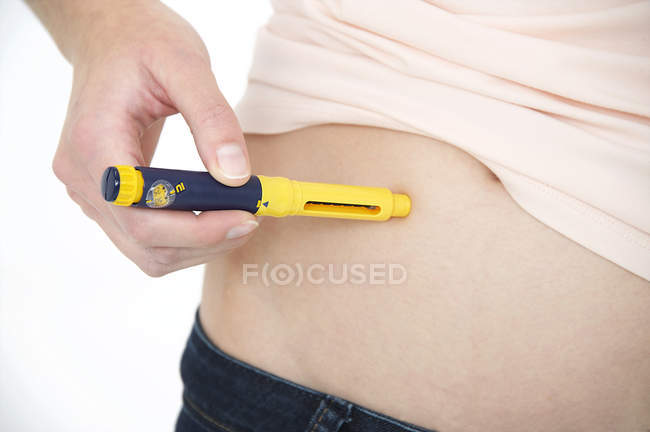 Vista cortada da mulher que faz a injeção no estômago com dispositivo médico . — Fotografia de Stock
