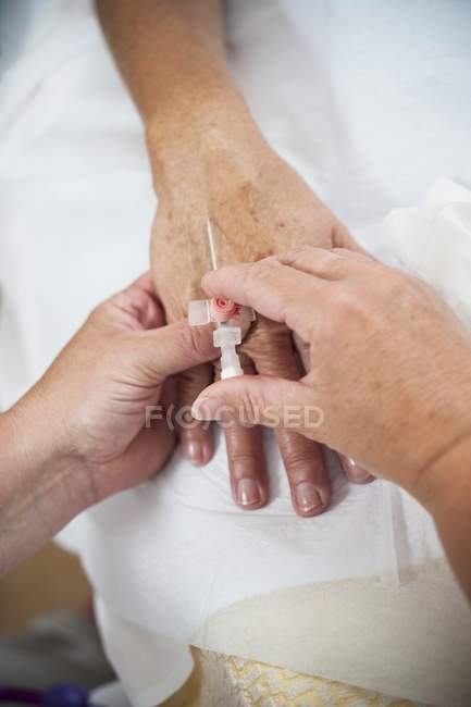 Close-up of nurse preparing patient for IV line. — Stock Photo