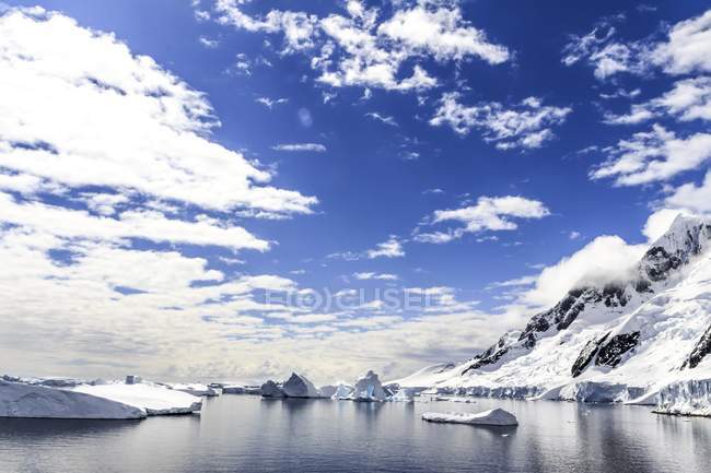 Montanhas que se elevam acima das margens de entrada do Canal Lemaire da Península Antártica . — Fotografia de Stock