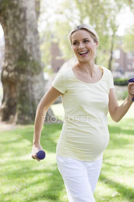Donna incinta che si esercita al parco — Foto stock