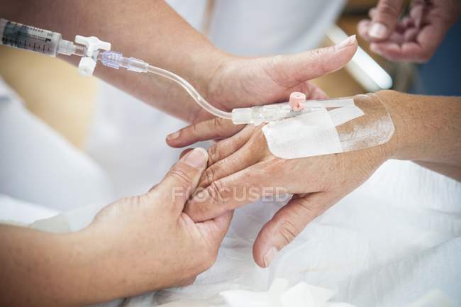 Nahaufnahme einer Krankenschwester, die Patientin auf die Injektionslinie vorbereitet. — Stockfoto