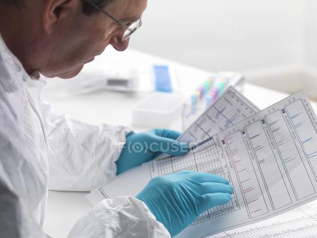 Cientista forense examinando resultados de sequenciamento de DNA . — Fotografia de Stock
