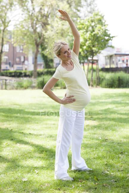 Pregnant woman stretching — Stock Photo