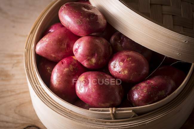 Close-up view of King Edward potatoes in bamboo steamer. — Stock Photo