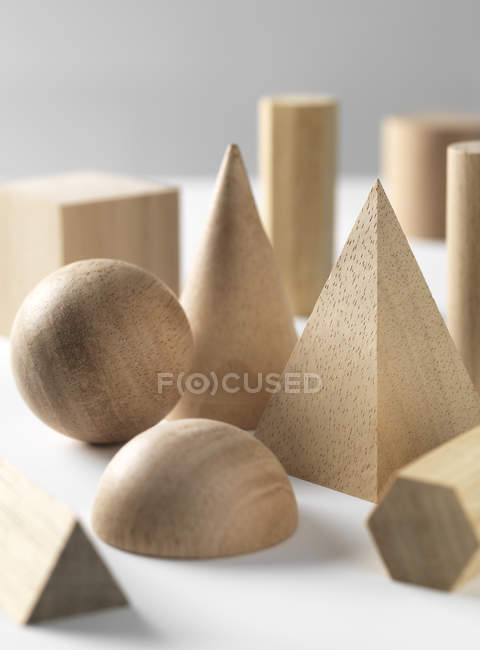 Figuras geométricas en forma de madera sobre mesa blanca . - foto de stock