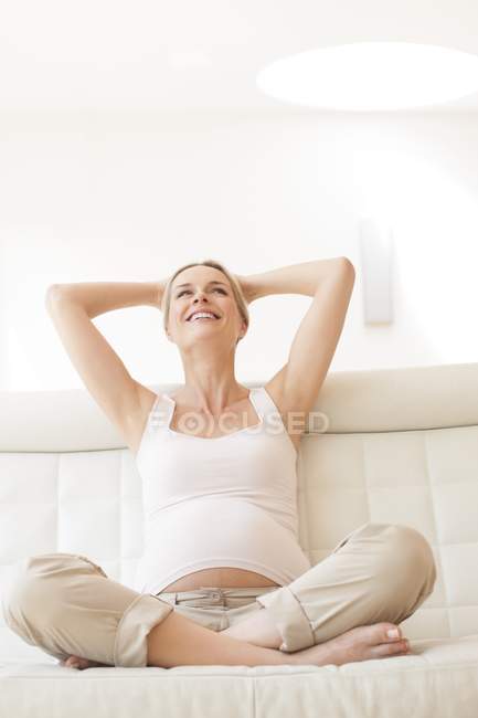 Pregnant woman relaxing on soffa — Stock Photo