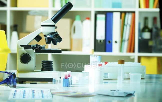 Microscopio luminoso su banco da laboratorio . — Foto stock