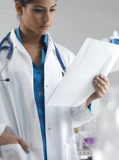 Doctor reading patient notes. — Stock Photo