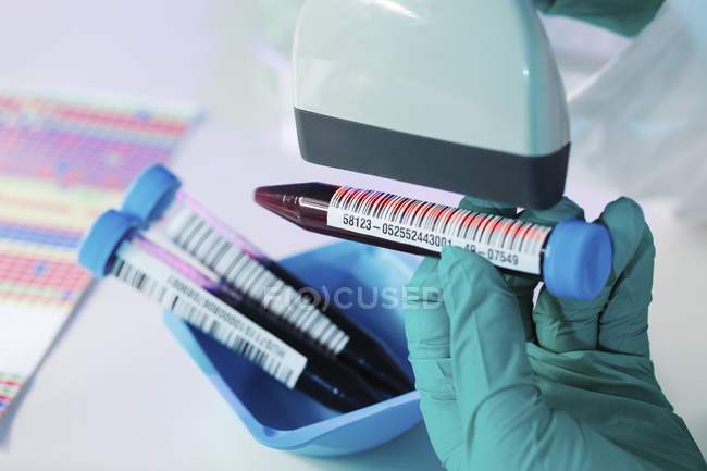 Close-up of scientist hand scanning tube with biological sample. — Stock Photo