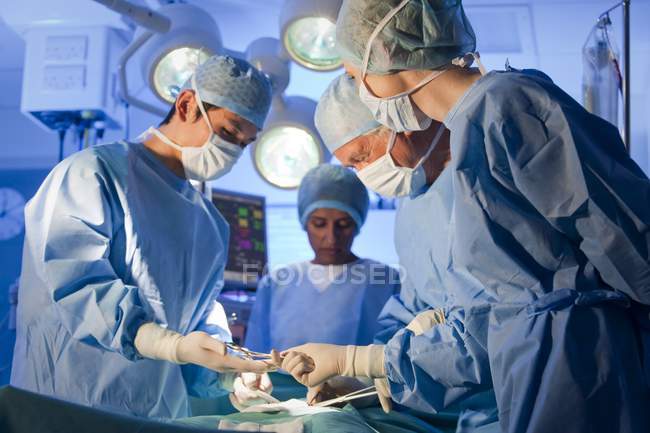 Chirurgie-Team mit Mundschutz arbeitet im Operationssaal. — Stockfoto