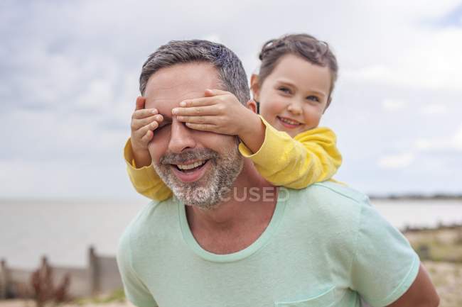 Daughter covering father eyes with hands. — Stock Photo