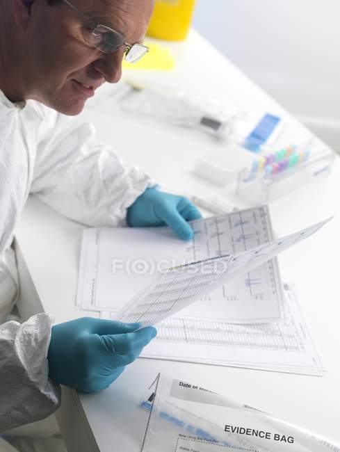 Científico forense examinando resultados de secuenciación de ADN . - foto de stock