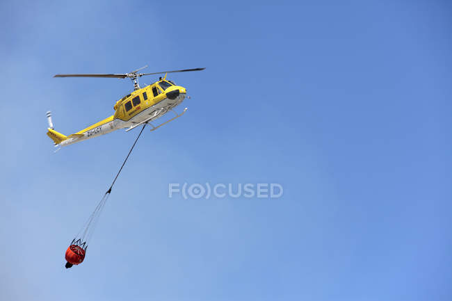 Helicóptero contra incendios de emergencia con cubo de agua en Ciudad del Cabo, Sudáfrica
. - foto de stock