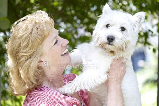 Зріла жінка тримає собаку . — стокове фото