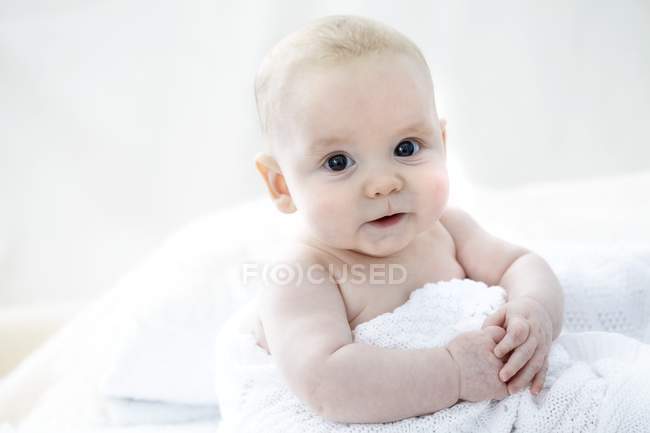Baby boy in blanket looking in camera, portrait. — Stock Photo