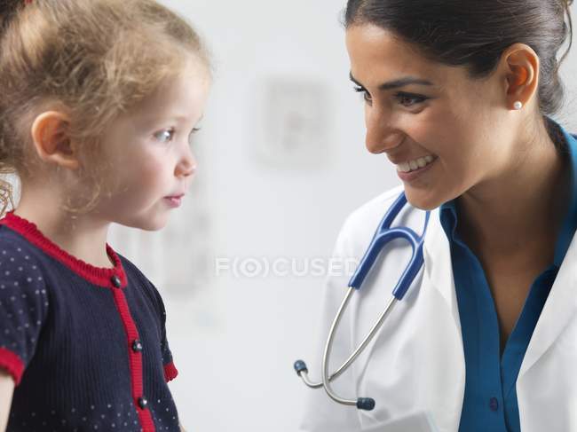 Pediatra donna che parla con ragazza in età prescolare . — Foto stock