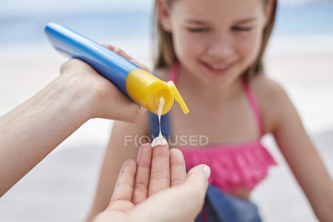 Hands applying sun cream to girl, close-up. — Stock Photo