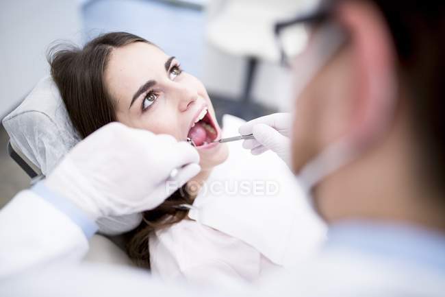 Dentista che esamina i denti del paziente in clinica dentale. — Foto stock